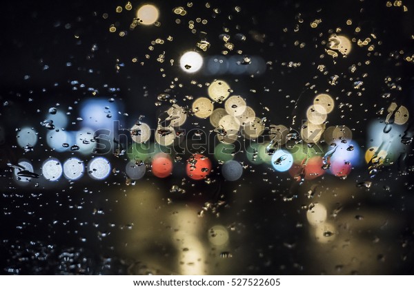 Wet the window with the background of the night
city traffic view.
