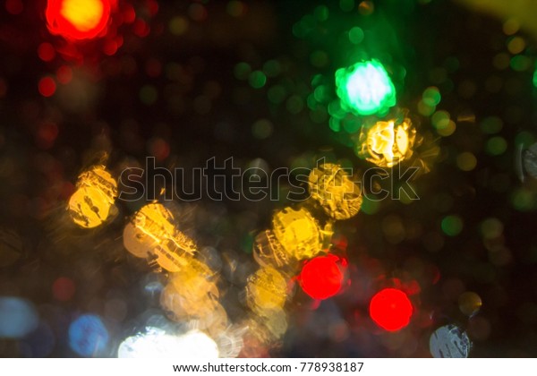 Wet the\
window with the background of the night city traffic view. Blurry\
image of inside cars with bokeh lights with traffic jam and raining\
on night time for background\
usage.