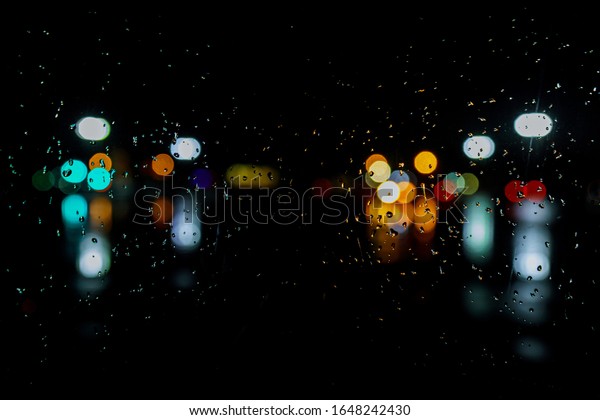 Wet the window with night rain and town lights\
night city background