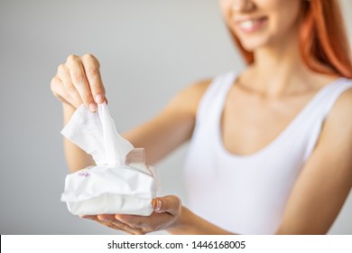 Wet wipes are universal an practical: red-hair women take one wipe from big package for cleaning