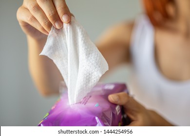 Wet wipes are universal an practical: woman take one wipe from big package for cleaning