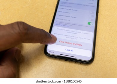 WETHERSFIELD, CONNECTICUT - DECEMBER 12, 2019: African American Man Holding Smart Phone About To Clear Browser History From Apple Safari Mobile Browser