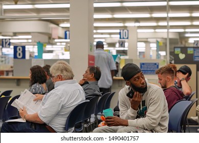 Wethersfield, CT / USA - June 11, 2019: Snapshot of a bored crowd of people in the waiting area (focus on african american man)