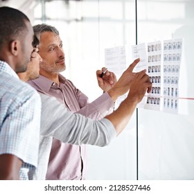 Weve Got Quite A Full Schedule. Shot Of A Group Of Male Colleagues Discussing Work In The Office.