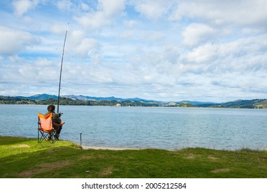 Whakatane New Zealand - May 26 2012; Lone Fisher At Ohiwa Harbour Rear View Patiently And Hopefully Waiting.