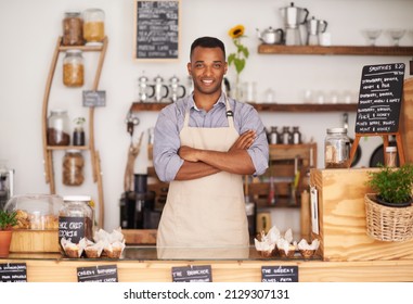 What Can I Get You. A Handsome Young Man Standing Behind The Counter Of His Cafe.