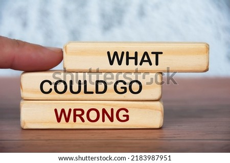 What could go wrong text on wooden blocks with blurred marble background. Problem solving concept