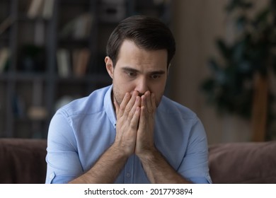 What to do. Worried nervous millennial man covering mouth with hands feeling fear panic attack having mental problems. Desperate scared man need psychological help can not see way out of life crisis