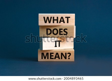 What does it mean symbol. Concept words 'what does it mean' on wooden blocks. Beautiful grey background. Businessman hand. Business and what does it mean concept. Copy space.