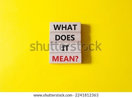 What does it mean symbol. Wooden blocks with words What does it mean. Beautiful yellow background. Business and What does it mean concept. Copy space.