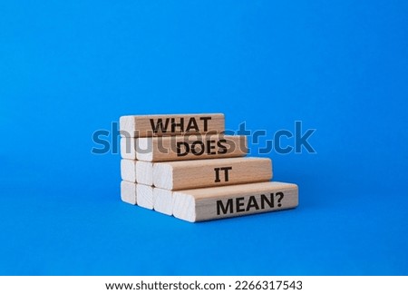 What does it mean symbol. Wooden blocks with words What does it mean. Beautiful blue background. Business and What does it mean concept. Copy space.