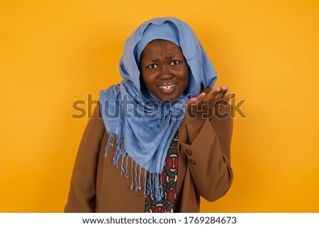 What the hell are you talking about, nonsense. Studio shot of frustrated female with gesturing with raised palm, frowning, being displeased and confused with dumb question over yellow wall.