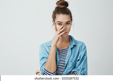 What The Hell Are You Wearing. Portrait Of Girl Who Feels Embarrassed, Covering Face With Palm, Looking At Something Pathetic With Unimpressed Look, Standing Against Gray Background