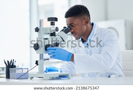 What an interesting find. Cropped shot of a focused young male scientist looking at test samples through a microscope inside of a laboratory during the day.
