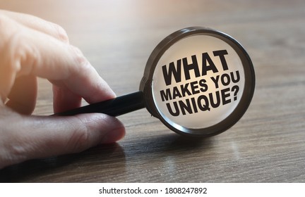 What makes you unique question under magnifying glass. Career business concept.