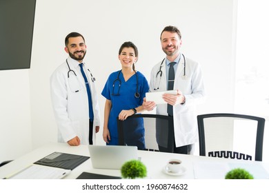 What A Rewarding Job. Portrait Of Three Happy Members Of The Medical Board Smiling And Making Eye Contact While Standing In The Meeting Room 