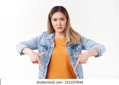 What suppose mean. Frustrated puzzled young concerned blond asian girl frowning perplexed pointing down squinting intense suspicious not believe add standing upset white background