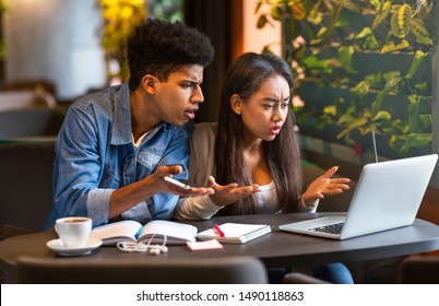 What Is Wrong. Angry Mixed Race Couple Of Students Looking Desperately At Laptop Screen, Studying At Cafe, Copy Space