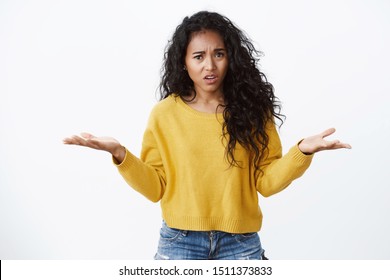 What wrong with you. Confused and intense pissed african-american woman in yellow sweater shrugging, spread hands sideways in dismay, complaining friend being late, white background - Shutterstock ID 1511373833