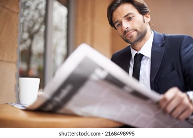 Whats Happening In The Business World Today. A Young Businessman Reading A Newspaper Outdoors At A Coffee Shop.