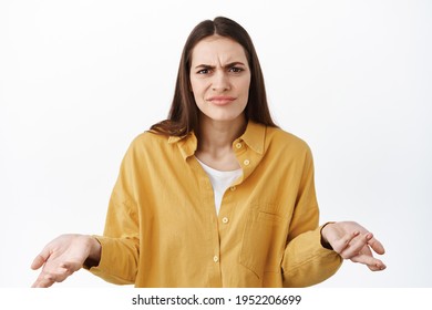 Whats Wrong I Dont Understand, Confused Woman Frowning And Raising Hands Clueless, Cant Tell, Know Nothing, Why Bother Gesture, Standing Over White Background