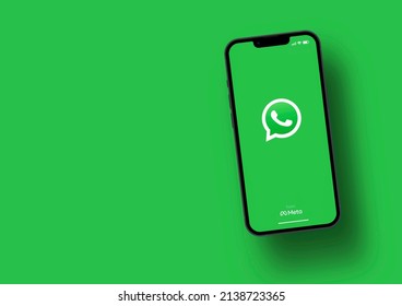 WhatsApp app on smartphone screen with large shadow giving the feeling of floating on top of the background. Green background. Rio de Janeiro, RJ, Brazil. March 2022.