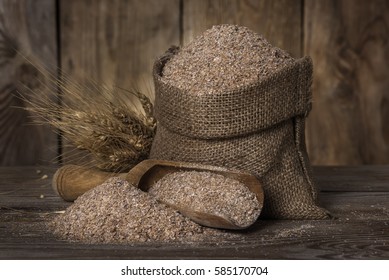 Wheat Bran In A Bag, Scoop And Ears Closeup On The Old Wooden Background, Rustic Style