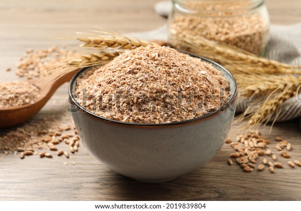 Wheat bran and kernels\
on wooden table