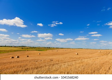 Wheat Field After Harvest With Straw Bales At Sunset