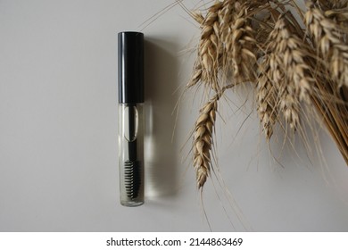 Wheat gel for styling eyebrows isolated on a white background. Care oil. Cosmetic product for the care of eyebrows and eyelashes. The transparent gel. Set of open and closed tube with a brush.