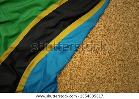 wheat grain on the waving colorful big national flag of tanzania .macro shot.