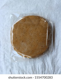 Wheat Thin Crust Pizza Base Packed Inside A Transparent Plastic Packet