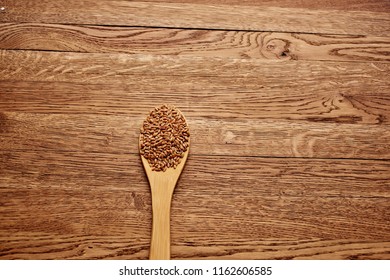 wheat in a wooden spoon on a table                               