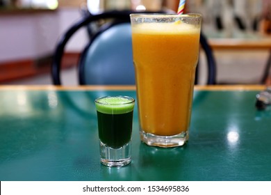 Wheatgrass Shot With Glass Of Pineapple And Mandarin Juice 