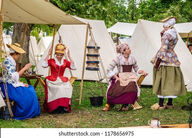 WHEATON, ILLINOIS/USA - SEPTEMBER. 8, 2018: Four Young Women In Period Dress Socialize In A Military Camp At A Reenactment Of The American Revolutionary War (1775-1783) In Cantigny Park.