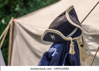 WHEATON, IL/USA - SEPT. 7, 2019: Closeup Of A Tricorne Hat Above A Blue Infantry Coat Hanging By A Tent In A Military Encampment At A Reenactment Of The American Revolutionary War (1775-1783).