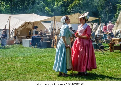 WHEATON, IL/USA - SEPT. 7, 2019: Two Women In Period Dress Have A Friendly Conversation In A Smoky Military Encampment At A Weekend Reenactment Of The American Revolutionary War (1775-1783).