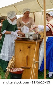 WHEATON, IL/USA - SEPT. 8, 2018: Three Young Women In Period Dress Wash And Dry Dishes Together In A Military Camp At A Reenactment Of The American Revolutionary War (1775-1783) In Cantigny Park.