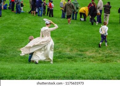 WHEATON, IL/USA - SEPT. 8, 2018: A Young Mother In Costume Holds Her Hat In One Hand And Her Son In The Other On The Way To A Skirmish At A Reenactment Of The American Revolutionary War (1775-1783).