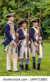 WHEATON, IL/USA - SEPT. 8, 2019: Three Continental Soldiers In Uniform, A Young Man And Two Young Women, Perform A Drill Together At A Reenactment Of The American Revolutionary War (1775-1783).