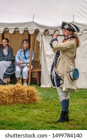 WHEATON, IL/USA - SEPT. 8, 2019: A Young Woman Fifer Plays A Period Piece While Two Women Watch From A Tent During A Demonstration At A Reenactment Of The American Revolutionary War (1775-1783).