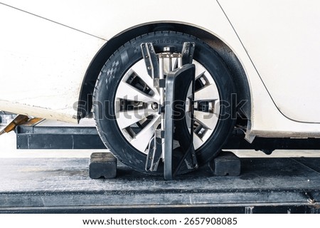 Wheel alignment or car alignment with radar sensor installing on rim, car maintenance service, automotive suspension repair.