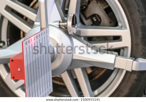 wheel\
alignment equipment is on the car wheel close\
up