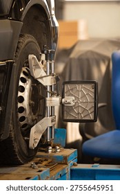 Wheel alignment sensor mounted on car wheel in auto service workshop. Vehicle diagnostics and adjustment process. Riga, Latvia – March 16, 2026.