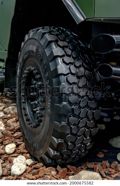 Wheel of\
an armored car. Close-up of a large off-road armored car tire on\
display at the international exhibition ARMS AND SECURITY - 2021.\
Selective focus. Kiev. Ukraine - June 18,\
2021.