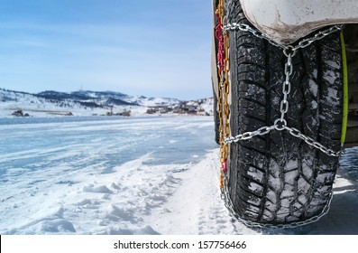 wheel of a car with chains on snow