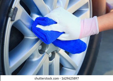 Wheel car cleaning and polished at alloy surface with blue microfiber or microfibre towel. Including with glove and hand. Result in shiny for car detailing, car washing and service business concept. - Powered by Shutterstock