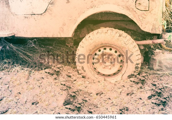 Wheel of car in mud\
on dirt road, closeup