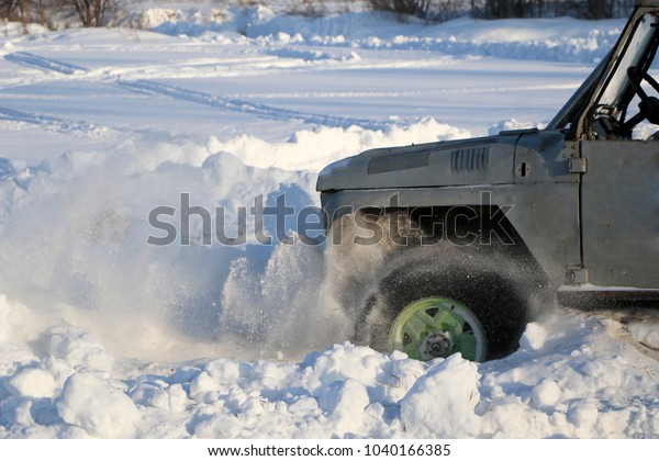  wheel of  car is
stuck in snow. spray of snow from  rotating wheel of winter tires.
slipping machine in  snow.  machine is in captivity of snowdrift
after  snowfall.