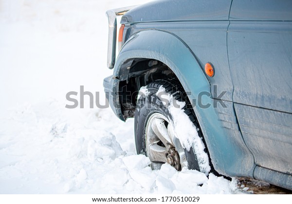 Wheel of a car\
stuck in the snow. Winter tires. Car tires for snow and ice.\
Almaty, Kazakhstan January 5,\
2020